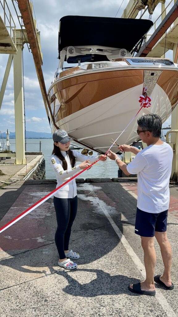 Ri230（2025年モデル）の前でテープカットをする男性と女性