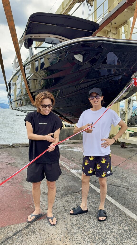 センチュリオンボート　Nv233の前でテープカットをする男性二人