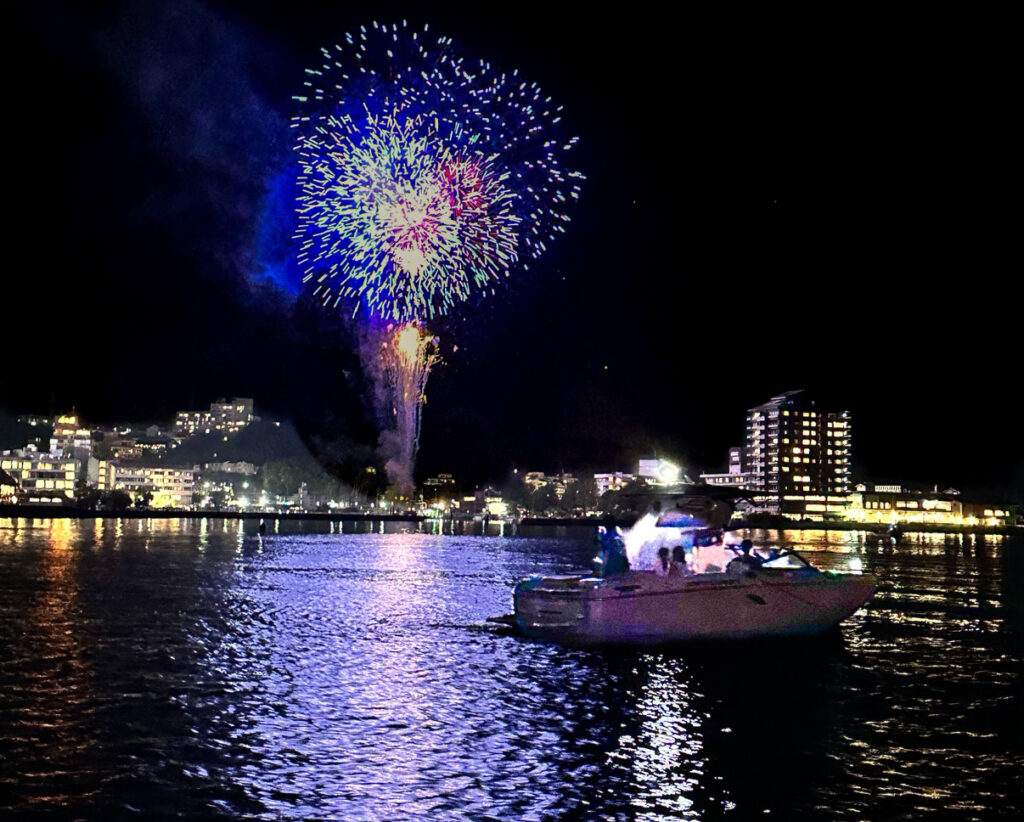打ちあがる花火と湖上に浮かぶボート
